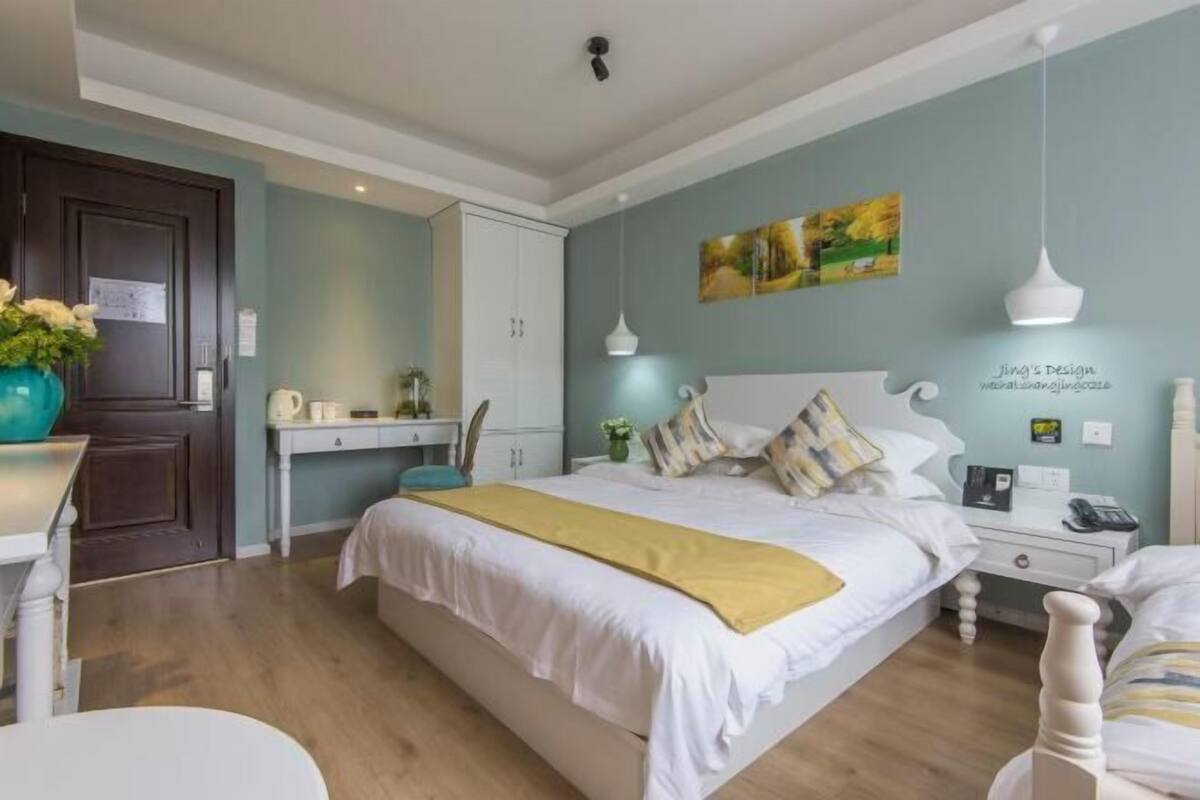 Un dormitorio con cama, mesitas de noche, un escritorio y una silla.