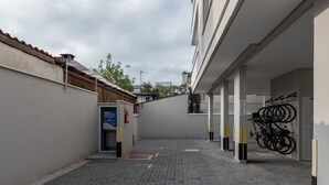 A narrow alleyway with a paved ground, a bike rack, and a building entrance. - Apt With Barbecue 2 min From Tenorio Beach Cah014 (Ubatuba)