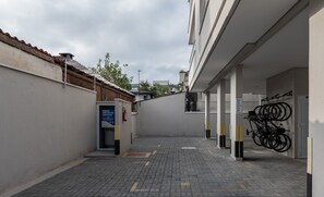 A narrow alleyway with a paved ground, a bike rack, and a building entrance. - Apt With Barbecue 2 min From Tenorio Beach Cah014 (Ubatuba)