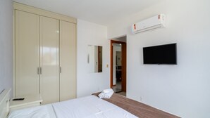 A bedroom with a bed, a wardrobe, a television, and an air conditioning unit. - 3BR apt W/bbq 240m sea Bombas/sc Cay0123 (Bombinhas)