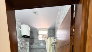 Une salle de bain équipée de toilettes, d’un lavabo, d’une douche et d’un miroir.