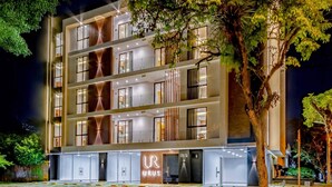 A multi-story hotel with a modern facade, large windows, and a ground floor entrance.