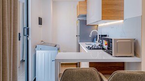 A compact kitchenette with a refrigerator, microwave, and sink.