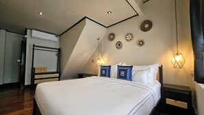 Un dormitorio con una cama grande, piso de madera, techo con iluminación empotrada y decoración en las paredes.