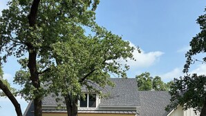 A two-story house with a front porch, a garage, and a well-maintained lawn.