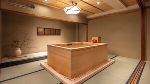 A traditional Japanese onsen with a wooden hot spring tub, tatami flooring, and a wooden ceiling. - Nazuna Kyoto Nishi Honganji (Kyoto)