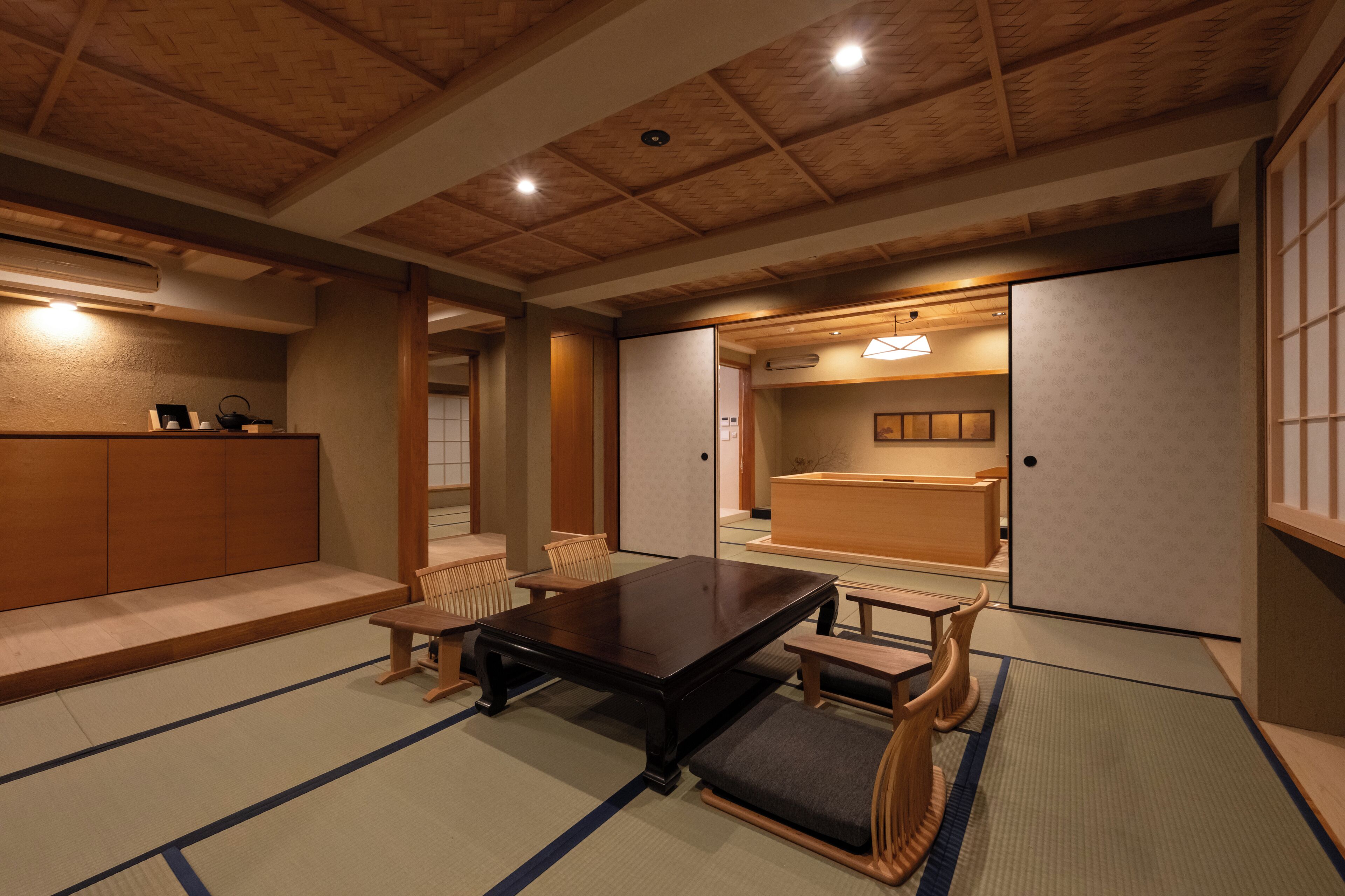 A traditional Japanese-style room with tatami flooring, a low wooden table, and sliding doors.