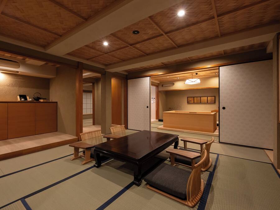 Une pièce de style japonais traditionnel, avec un sol recouvert de tatamis, une basse table en bois et des portes coulissantes.