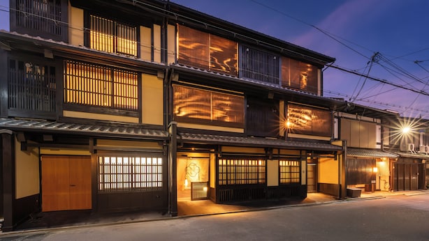 A traditional Japanese building with multiple floors, wooden sliding doors, and a well-lit entrance. - Nazuna Kyoto Nishi Honganji (Kyoto)