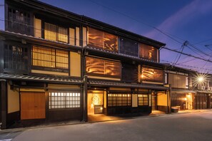 A traditional Japanese building with multiple floors, wooden sliding doors, and a well-lit entrance. - Nazuna Kyoto Nishi Honganji (Kyoto)