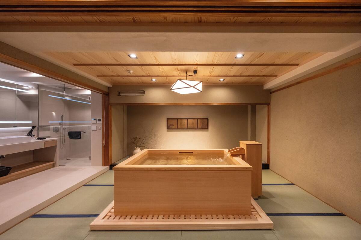 Ein traditionelles japanisches Onsen mit Holzbad, Empfangsbereich und minimalistischem Interieur.