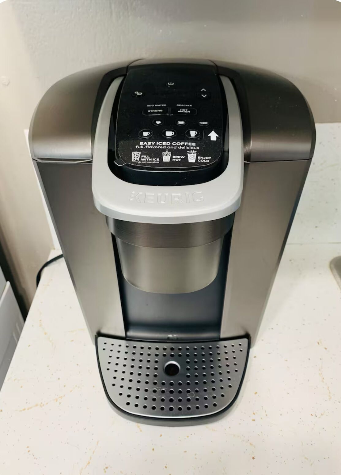 A Keurig coffee maker with a control panel for making iced coffee.