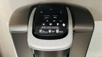 A Keurig coffee maker with a control panel for making iced coffee.