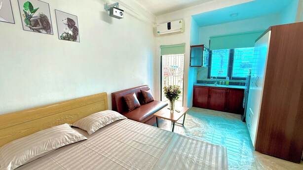 Une chambre d’hôtel avec un lit, un canapé, une petite table et une vue sur la cuisine.