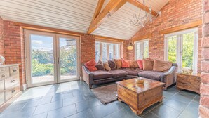 A spacious living room with a sectional sofa, a wooden coffee table, and a fireplace.