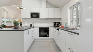 A modern kitchen with white cabinetry, a built-in oven, and a dishwasher. - VillaVilla 803 - Fjellerup, Østjylland (Glesborg)