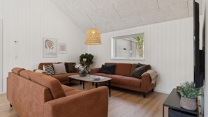 A living room with a brown sofa set, a coffee table, and a hanging light fixture. - VillaVilla 807 - Fjellerup, Østjylland (Glesborg)