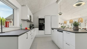 Eine moderne Küche mit weißen Schränken, einem schwarzen Backofen und einem integrierten Geschirrspüler.