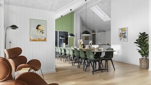 A modern dining area with a long table, green chairs, pendant lights, and a potted plant. - VillaVilla 810 - Fjellerup, Østjylland (Glesborg)