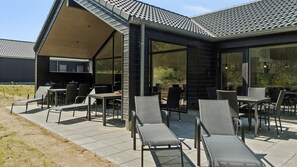 A modern outdoor patio with lounge chairs and a dining area.