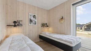 A room with two beds, a framed picture, a lamp, and a basket. - VillaVilla 832 - Fjellerup, Østjylland (Glesborg)