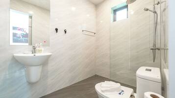 A modern bathroom with a sink, toilet, and shower.