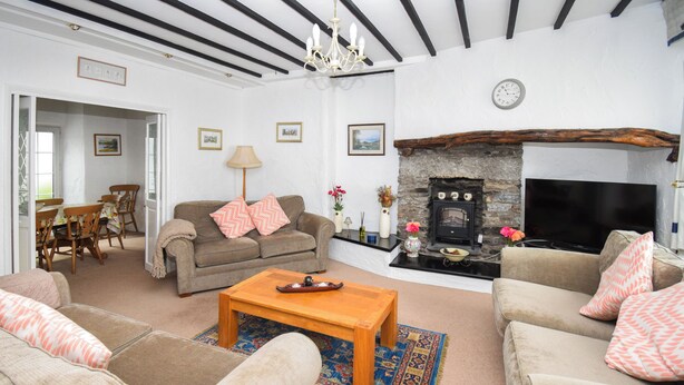 A living room with a fireplace, sofas, a coffee table, and a television.