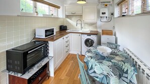 Una cocina compacta equipada con microondas, tostadora y lavadora.