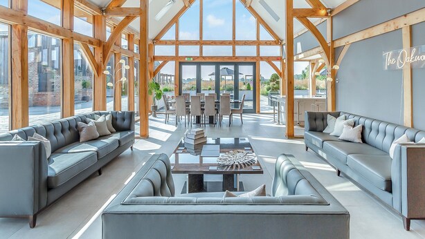 A spacious interior with high ceilings, wooden beams, and large windows. - 5 bedroom accommodation in Ryther (Ryther)