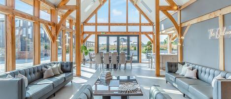 A spacious interior with high ceilings, wooden beams, and large windows.