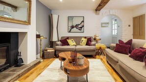 A living room with a fireplace, a sofa set, a coffee table, and a large mirror.