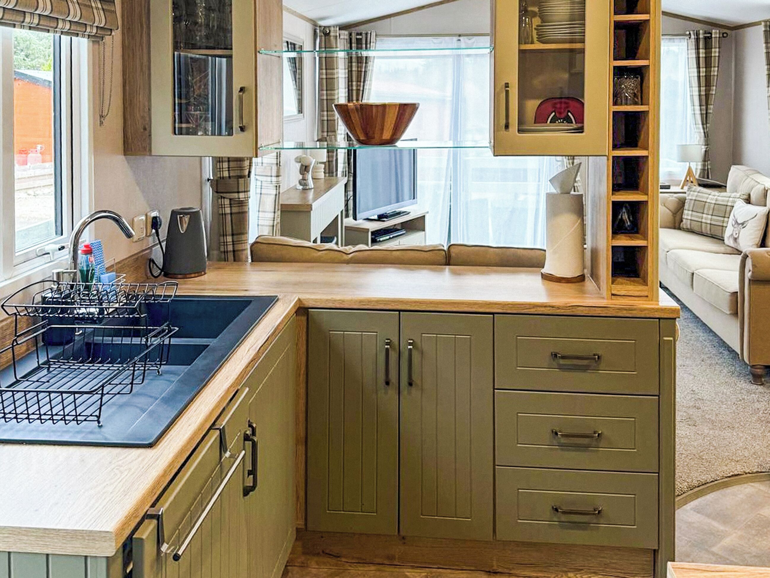 A compact kitchen with a sink, cabinets, and a dining area.