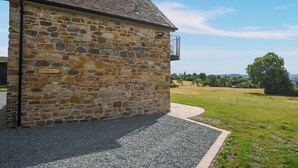 A stone building with a gravel driveway and a view of the countryside. - 1 bedroom accommodation in Shropshire (Shropshire)