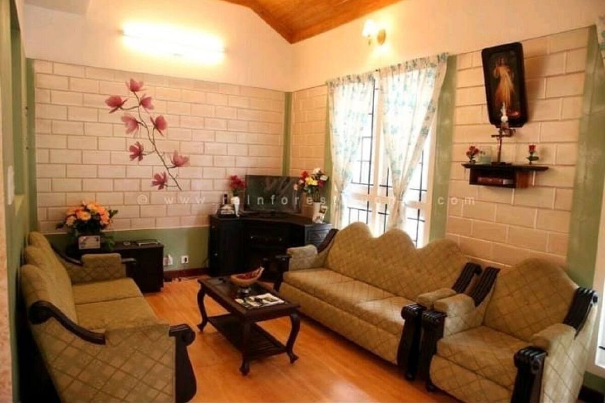 Una sala de estar con sofá, sillones, una mesa de centro y chimenea.