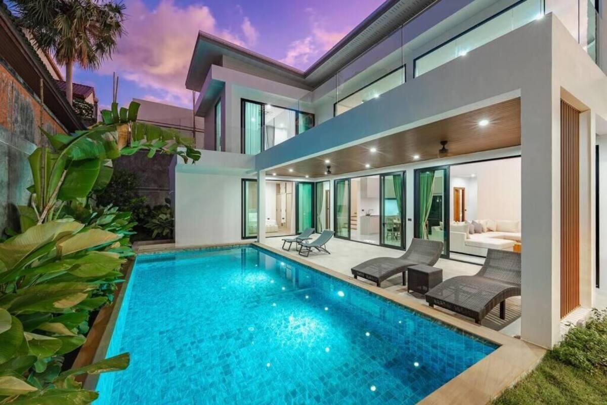 A modern house with a swimming pool, large windows, and outdoor furniture.