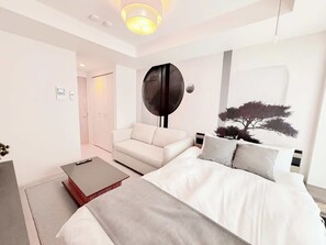 A modern bedroom with a bed, a sofa, and a coffee table. - Triphome Sugamo Otsuka 2025 New 7 mins 2 stations (Toshima City)