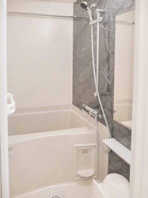Une salle de bain moderne avec une douche à l’italienne, une baignoire et des toilettes.