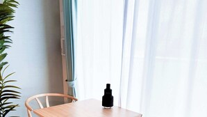 A room with a wooden table and two wicker chairs, a potted plant, and a window with sheer curtains. - Triphome Sugamo Otsuka 2025 New 7 mins 2 stations (Toshima City)