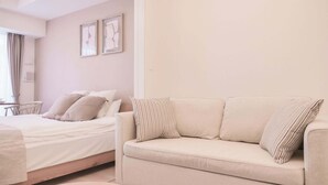 Une chambre à coucher moderne avec un lit, un canapé et une petite table.