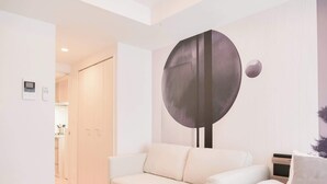 Un salón moderno con un sofá blanco, una mesa de centro y una gran obra de arte abstracta en la pared.