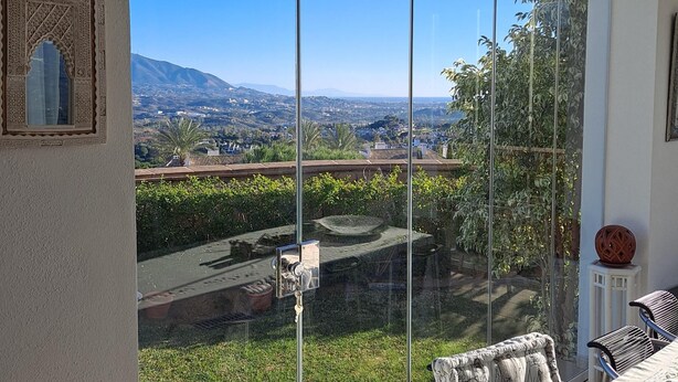 Ein Balkon mit freiem Blick auf Stadt und Berge.
