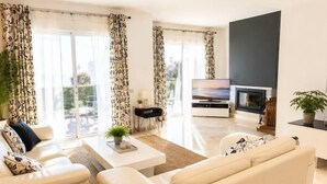 Ein modernes Wohnzimmer mit Sofa, Couchtisch und Fernseher.