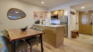 Una cocina moderna con una isla central, armarios de madera y electrodomésticos de acero inoxidable.