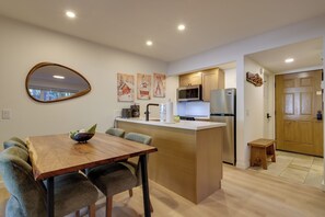 Une cuisine moderne dotée d’un îlot central, de meubles en bois et d’appareils électroménagers en acier inoxydable.