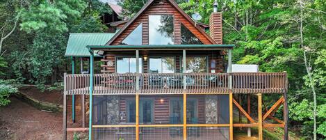 From above, admire the charm of our cabin with its expansive wraparound deck and a screened-in bottom porch—perfect for soaking in the scenery from every angle.