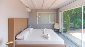 A modern bedroom with a large bed, a bedside table with a lamp, and a view of the outdoors through a large window. - WELCS APARTMENT 282 EMP in villa with swimming pool com (Rosas / Roses)