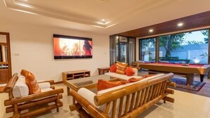 A modern living room with a pool table, comfortable seating, and a large TV screen. - CoconutPalmsJacuzzipoolhugeproperty v136 (Rawai)