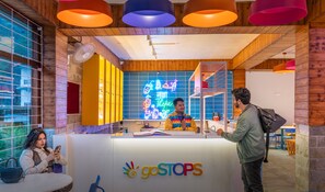 Un espace d’accueil de GoStops avec un panneau néon, un décor intérieur en bois et un panneau indiquant que l’accès est réservé aux personnes de 18 ans et plus.