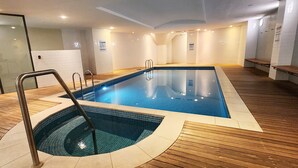 A swimming pool with a wooden deck, a diving board, and a changing room area. - Paddington’s Finest Address, Blending History & Sophistication (Paddington)