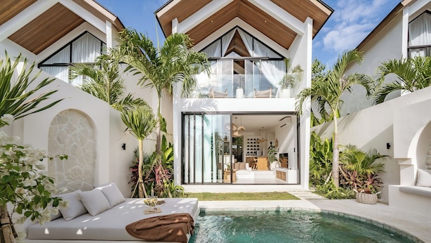 Uma casa moderna com piscina, área de estar ao ar livre e vegetação exuberante.